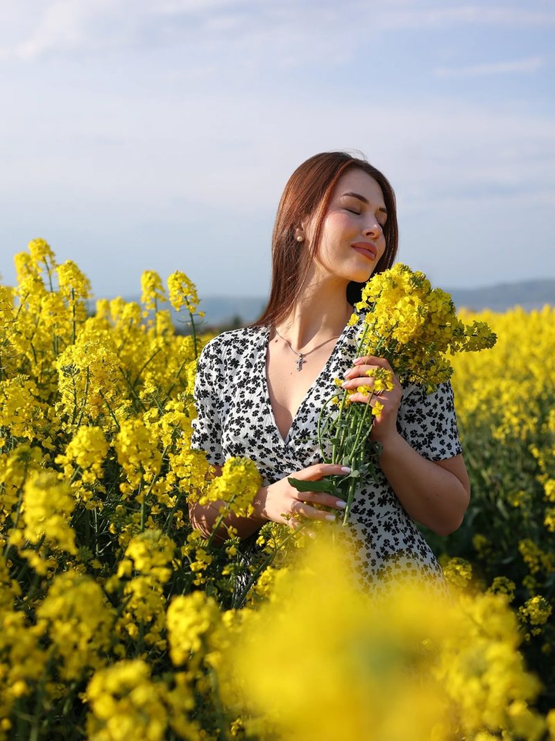 Женщина нюхает полевые цветы
